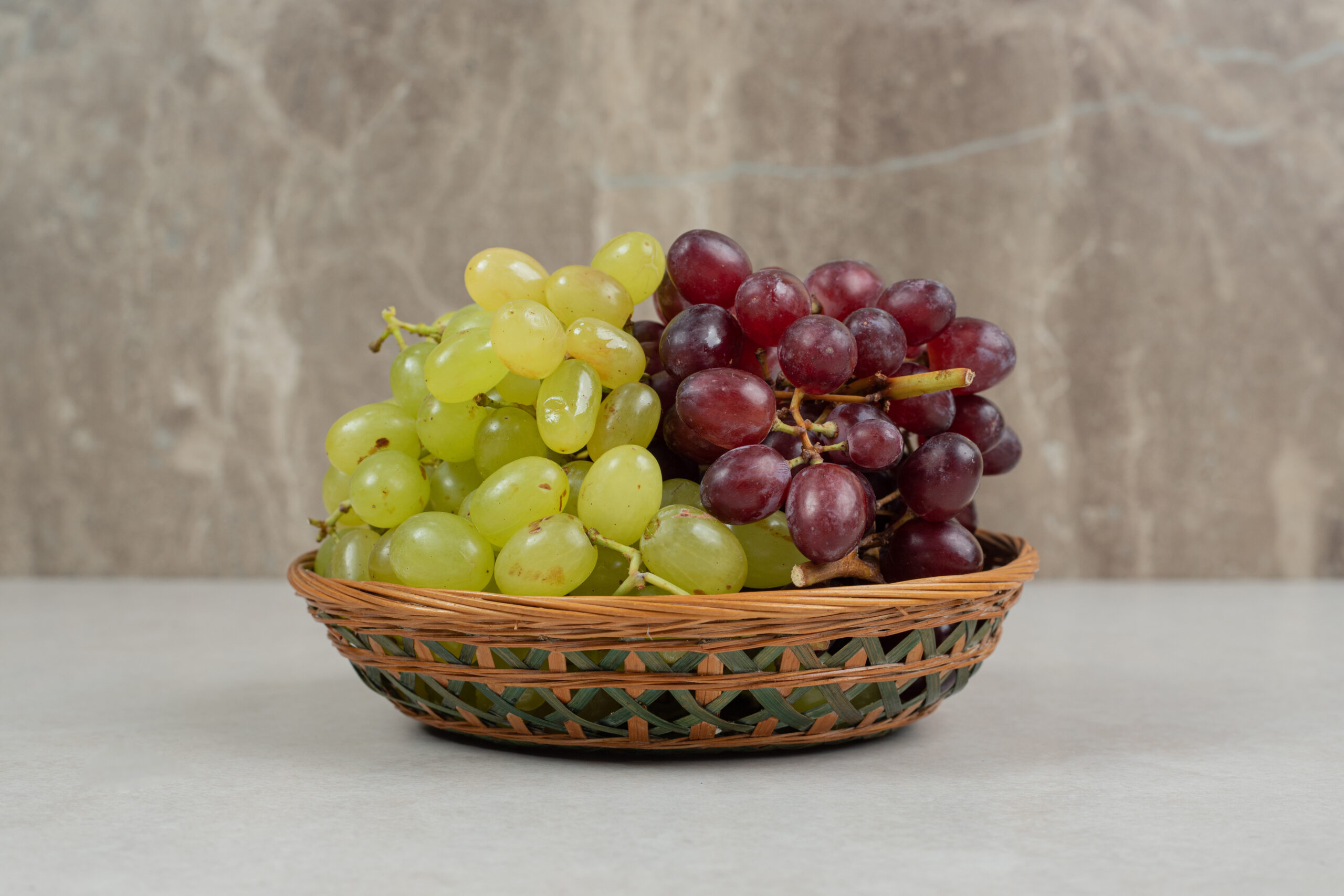 Fresh red and green grapes in wooden basket. High quality photo