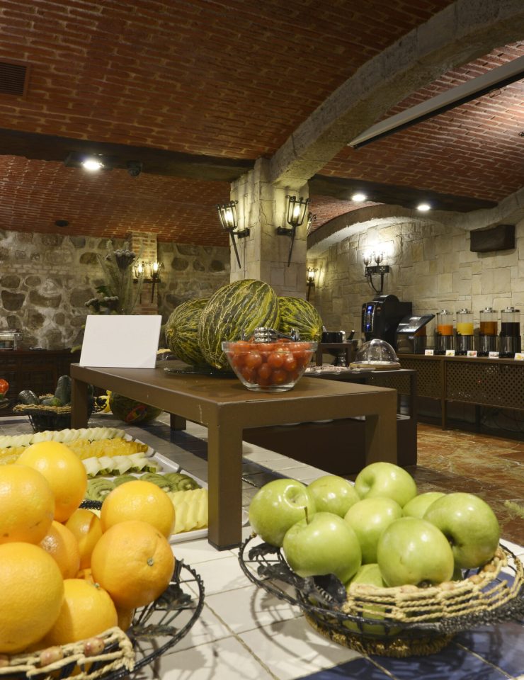 dining room of a hotel with baskets full of pieces of fruit and chopped fruit on trays